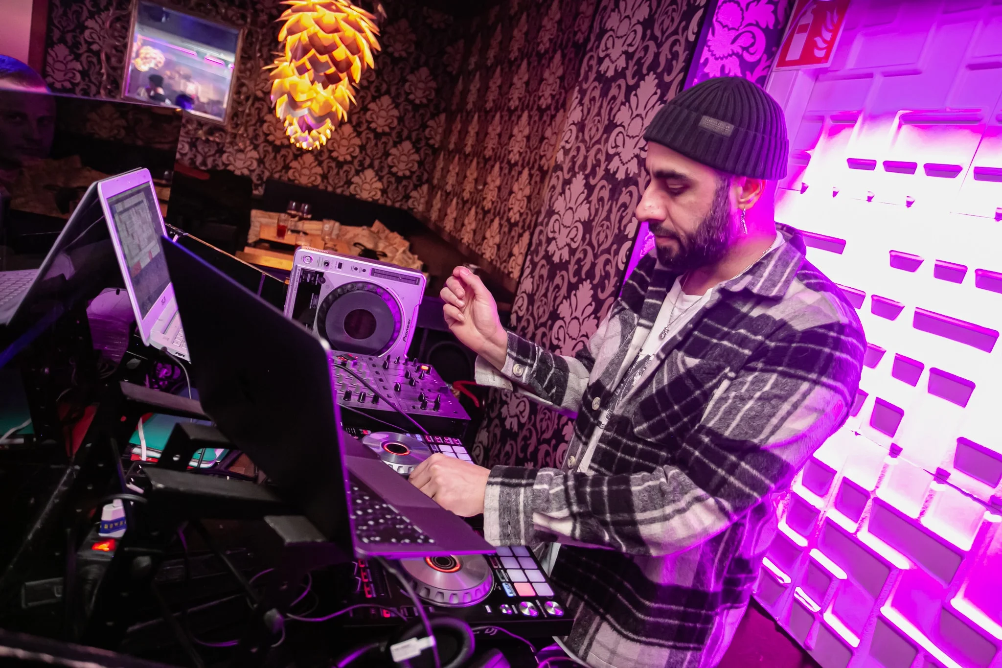 DJ Snabu soittamassa DJ-laitteistolla pipossa ja ruutupaidassa