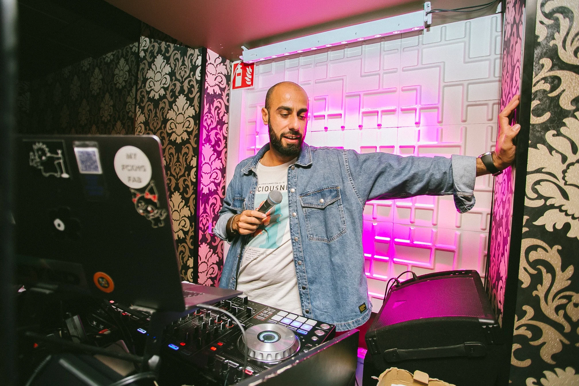 DJ Snabu mikrofoni kädessään ravintolan DJ-pisteellä