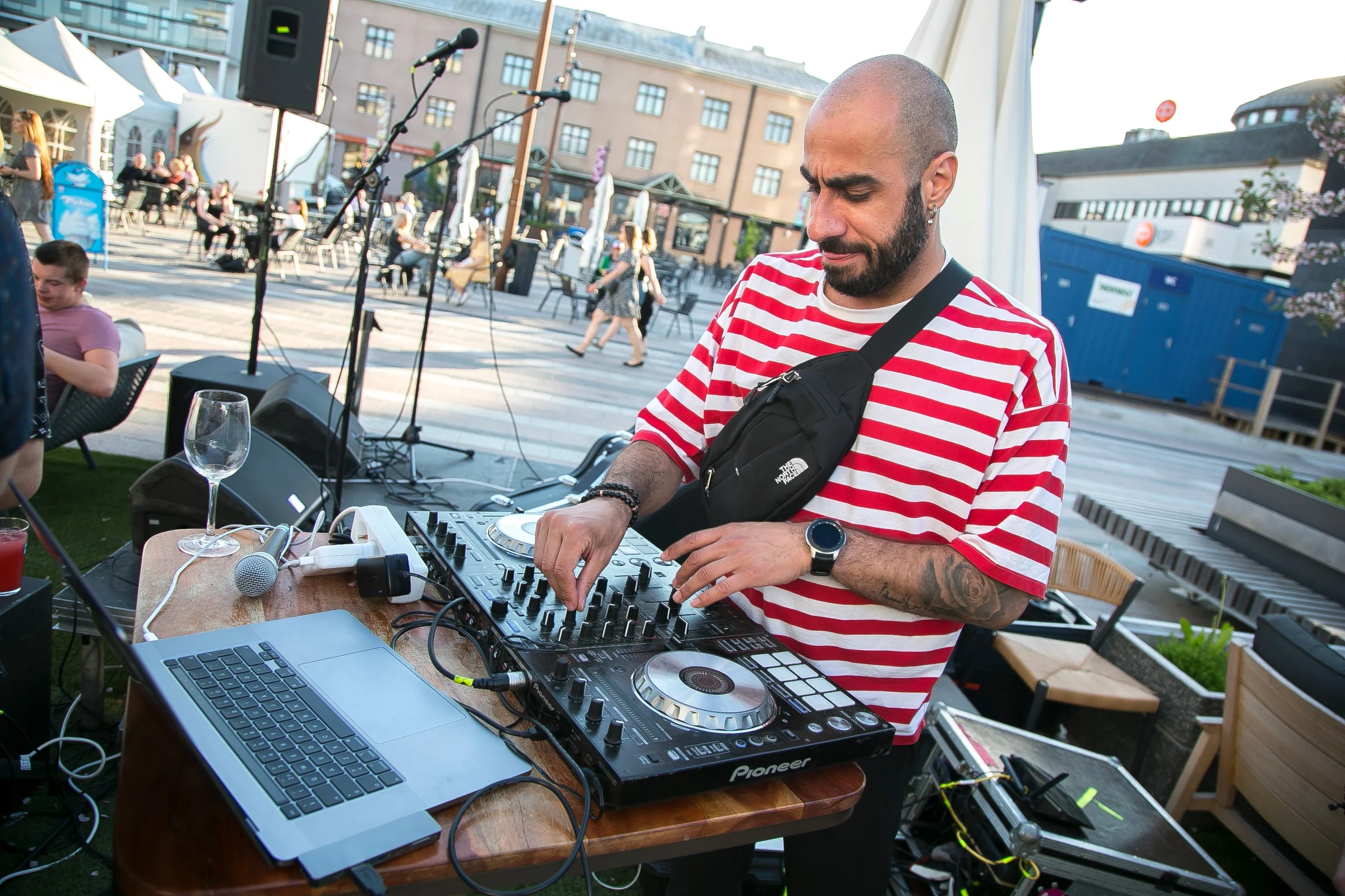 DJ Snabu soittamassa raidallisessa paidassa ulkoterassilla